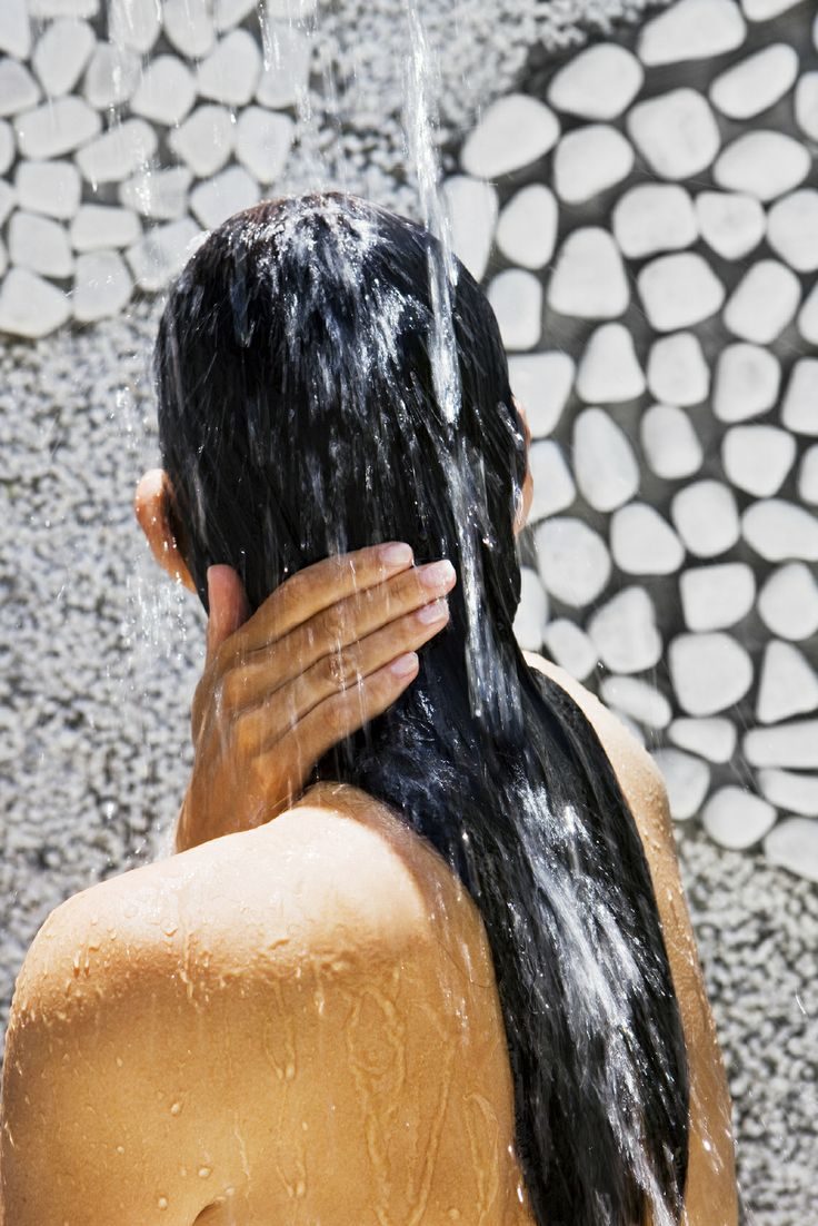 woman-under-outdoor-water-shower-at-spa-centre
